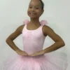 Pequena bailarina usando o Figurino Primeiros Passos Infantil rosa da Lucia Caliman, com saia de tule volumosa e detalhes florais no ombro, em uma pose clássica de ballet.