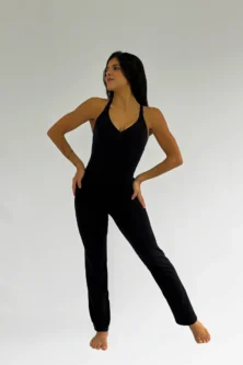 Bailarina vestindo a Calça Bailarina Adulto preta da Lucia Caliman, combinada com um collant preto, em pose de dança com as mãos na cintura.