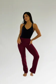 Dançarina com a Calça Bailarina Adulto na cor vinho da Lucia Caliman, em pose elegante que mostra a flexibilidade e o corte da calça.