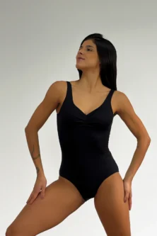 Bailarina vestindo o Collant 806 preto da Lucia Caliman olha para o lado, destacando o caimento da peça no corpo.