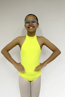 Jovem bailarina de frente em pose de preparação usando o Collant Infantil Frente Única na cor Amarelo Candy da Lucia Caliman