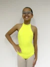Jovem bailarina de frente, com a mão direita na cintura usando o Collant Infantil Frente Única na cor Amarelo Candy da Lucia Caliman.
