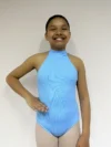 Vista frontal de uma jovem bailarina com a mão direita na cintura, vestindo o Collant Infantil Frente Única Azul Candy da Lucia Caliman
