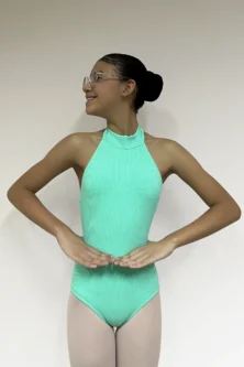 Bailarina infantil olhando para o lado direito, veste o Collant Frente Única em Rosa Candy da linha Imaginário Candy da Lucia Caliman em pose graciosa.