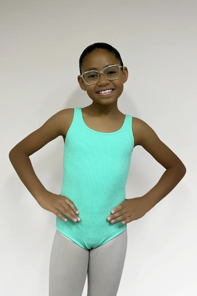 Jovem dançarina usando o Collant Infantil Quadrado Verde Candy da Lucia Caliman, visto de frente em fundo neutro.