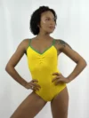 Modelo de pele negra e cabelos cacheados usando o Collant Ana Paula amarelo canelado da Lucia Caliman, com as mãos na cintura em pose de prontidão.