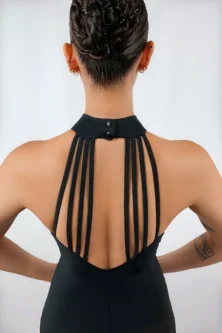 Bailarina de costas exibindo o Collant Frente Única Quatro Tiras preto da Lucia Caliman, com foco no design deslumbrante de tiras verticais nas costas nuas e na postura elegante com mãos na cintura.