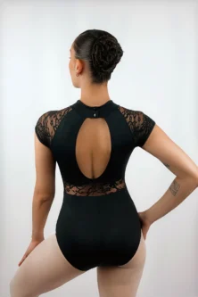 Ângulo detalhado das costas da bailarina vestindo o Collant Manga Japonesa preto da Lucia Caliman, evidenciando o caimento perfeito do decote vazado e a modelagem anatômica da peça.