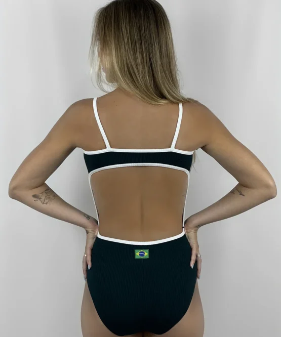 Vista posterior da modelo loira usando o Collant Marta verde com branco, destacando o recorte oval nas costas e a pequena bandeira do Brasil no centro.