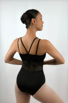 Bailarina usando o Collant Recorte Cintura preto da Lucia Caliman, vista de costas em leve diagonal, exibindo as alças duplas cruzadas e o elegante recorte em renda na região da cintura.
