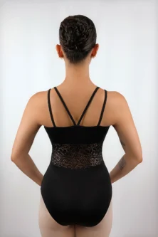 Bailarina usando o Collant Recorte Cintura preto da Lucia Caliman em vista posterior direta, com as mãos na cintura, destacando a simetria das alças finas nas costas e a delicadeza da renda transparente.