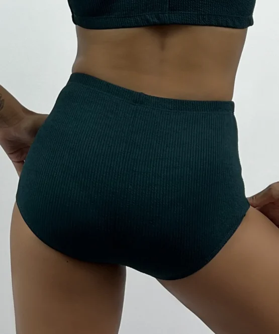 Vista posterior da Hot Pant Vina verde militar em modelo de costas, exibindo o cós alto anatômico e a cobertura total e confortável nos glúteos.