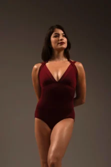 Modelo em pose clássica frontal vestindo o Collant Duna vinho, evidenciando o caimento elegante e o tom sóbrio da peça.