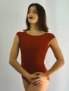 Bailarina vestindo o Collant Ana na cor terracota da Lucia Caliman, com decote canoa e mangas curtas, em pose confiante de frente, destacando o caimento perfeito no corpo.