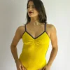 Bailarina vestindo o Collant Marta amarelo e azul, da Coleção Brasilidades, da Lucia Caliman. A peça canelada possui alças finas azuis, decote em V com efeito fratê frontal e ajuste anatômico impecável.