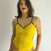 Bailarina veste o Collant Marta amarelo canelado da Lucia Caliman. A peça possui acabamentos e alças finas na cor verde, além de um delicado decote em V com franzido frontal e caimento perfeito.