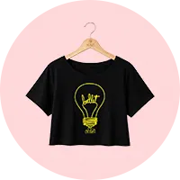 Camiseta preta cropped com estampa de lâmpada amarela contendo o texto 'Dance' e silhueta de bailarina, pendurada em cabide de madeira sobre fundo rosa claro.