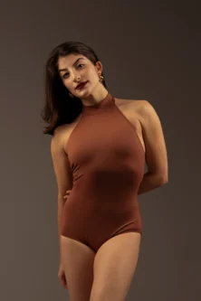 Bailarina vestindo o Collant Frente Única caramelo da Lucia Caliman, vista de frente em postura elegante e confiante.
